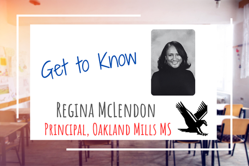 background graphic of a generic classroom. over that photo is a white box with text stating, Get to Know Regina McLendon Principal, Oakland Mills MS. Also in the box is a photo of Regina McLendon and the falcon mascot for Oakland MIlls Middle School